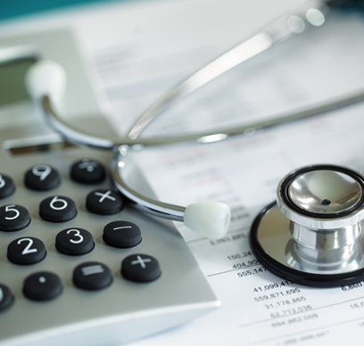 A calculator and stethoscope resting on financial statements